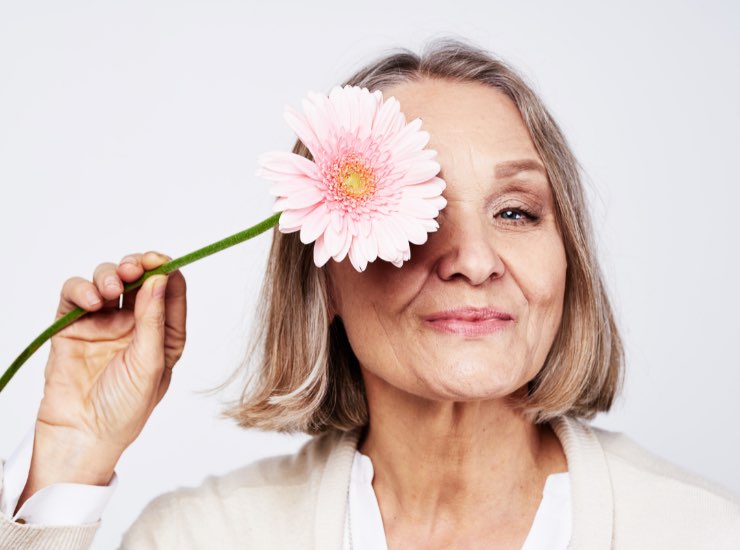 Una donna anziana con un fiore